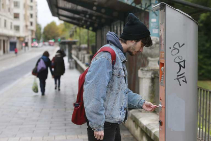Un joven recarga su tarjeta de autobús en la parada de la avenida Arlanzón.-RAÚL G. OCHOA