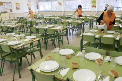 Varias monitoras de comedor preparan las mesas en un colegio. RAÚL G. OCHOA
