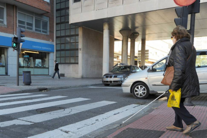 Una mujer invidente cruza un paso de peatones de la ciudad.-Israel L. Murillo