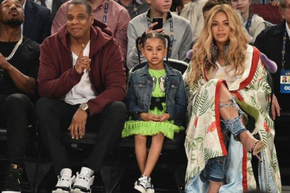 Blue Ivy, con sus padres en un partido de la NBA.-AFP