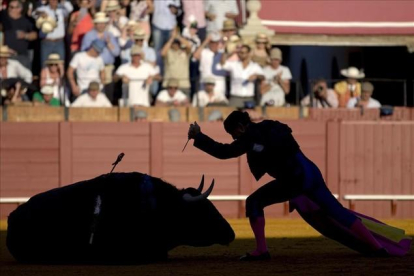 Un torero da el "golpe de gracia" a un toro durante una corrida de toros en la plaza de toros de la Maestranza de Sevilla-REUTERS / MARCELO DEL POZO