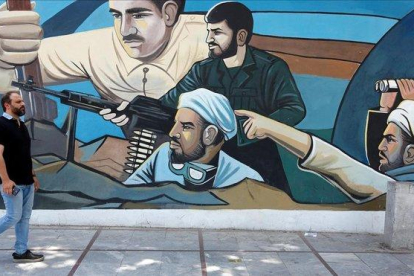 Un hombre camina delante de un mural en Teherán (Irán).-ABEDIN TAHERKENAREH (EFE)