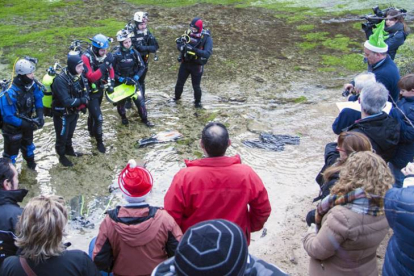 Cristina Gutiérrez sujeta el Belén en compañía de su hermano Gustavo y miembros del Club Delfín Burgos antes de proceder a sumergirse en el Pozo Azul.-Ricardo Ordóñez (Ical)