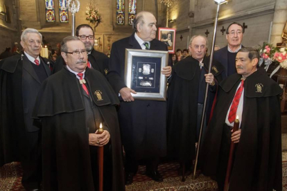 Juarranz, arriba a la derecha, junto a otros cofrades de San Antón tras la misa dedicada a la Virgen de Las Candelas en la Antigua entregan a José María Peña, exalcalde de Burgos, el premio de Tito de Oro 2015.-SANTI OTERO