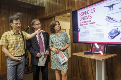 Fidel Torcida, director del Museo,  Ángel Garzón, Fundación Caja Rural, y Raquel Arroyo Fundación Dinosaurios, observan los elementos de la nueva app.-SANTI OTERO