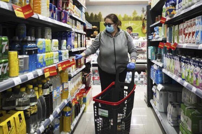 Una mujer con mascarilla, en un supermercado. EL MUNDO