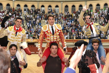 Talavante, Manzanares y Padilla saliendo a hombros en el triunfal festejo que cerró la feria el sábado.-ALBERTO CALVO