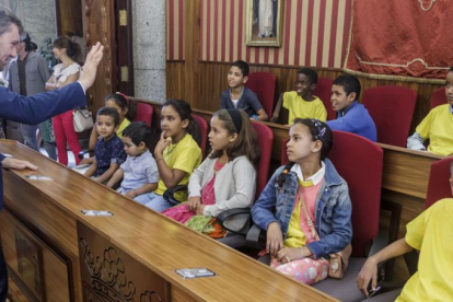 Los niños saharauis sentados en el salón de plenos del Ayuntamiento mientras el alcalde, Javier Lacalle, les saluda.-SANTI OTERO