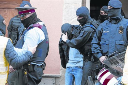 Uno de los detenidos en Roda de Ter es trasladado por los Mossos.-LAURA BUSQUETS