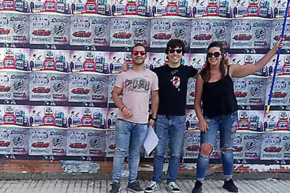 Tres de los organizadores del festival posan sonrientes tras una de sus tradicionales pegadas de carteles en Villarcayo.-DOLMEN MUSIC FEST