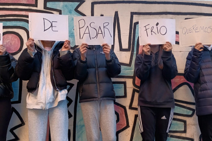 Un grupo de adolescentes posa con unos carteles en los que se lee: «Hartos de pasar frío queremos sitio».