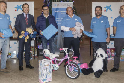 Representantes de los voluntarios, la entidad bancaria y la Diputación, con algunos de los juguetes que este año llegarán a 345 familias.-S. O.