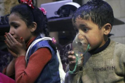 Niños reciben oxígeno, tras el ataque químico.-/ AP