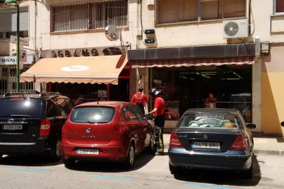 Dos bomberos trabajan en el exterior de la carnicería afectada, en la avenida del Vena.-ECB