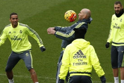 Zidane controla el balón ante Benzema y Danilo durante el entrenaminento de este viernes en Valdebebas.-EFE / JUAN CARLOS HIDALGO