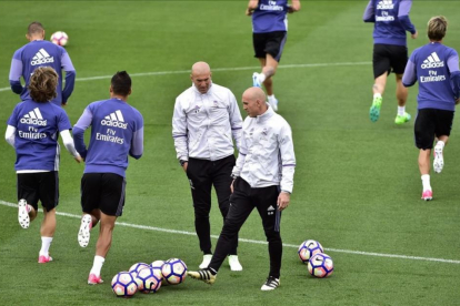 Zidane y su segundo, Bettoni, durante el entrenamiento de este viernes en Valdebebas.-AFP