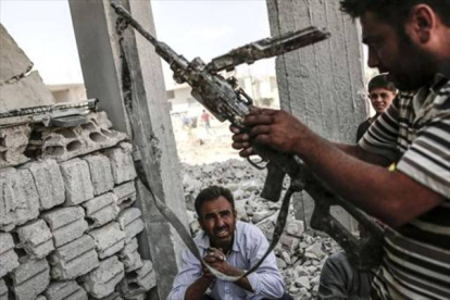 Un hombre con un arma incautada el Estado Islámico en Kobane.-AFP PHOTO/YASIN AKGUL