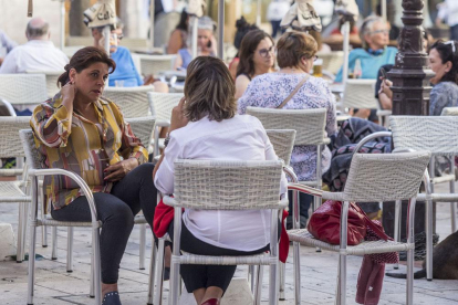 Varias personas disfrutan del buen tiempo en una terraza.-SANTI OTERO