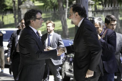 Carles Puigdemont y Mariano Rajoy se saludan este viernes, en Barcelona, antes de la inauguración del Salón de Automóvil de Barcelona.-JOAN CORTADELLAS