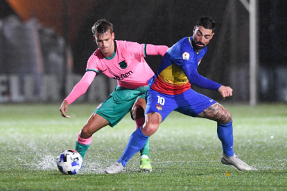 Un jugador del FC Andorra disputa un balón con un defensor del Barça B en un choque de esta campaña. FC ANDORRA