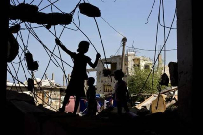 Unos niños palestinos juegan en las ruinas de un edificio destruido.-Foto: AFP/ MOHAMMED ABED