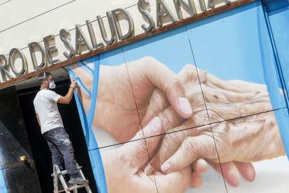 Christian Saldaña trabaja en el mural que está rematando en el centro de Salud de Santa Clara. FOTOS: © ECB / SANTI OTERO