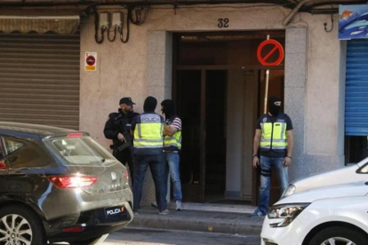 Agentes de la Policía Nacional montan guardia en la puerta del domicilio de uno de los presuntos yihadistas detenidos este miércoles en Canovelles (Barcelona).-ACN / JORDI PUJOLAR