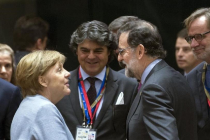 Merkel y Rajoy se saludan antes del comienzo de la cumbre.-EFE