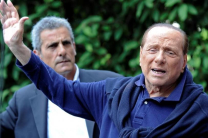 Berlusconi (derecha), al salir del hospital tras operarse del corazón, en Milán, el 5 de julio del 2016.-REUTERS / FLAVIO LO SCALZO