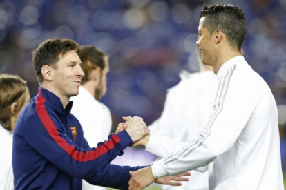 Messi y Cristiano se saludan en la previa del Barcelona-Real Madrid del pasado mes de abril.-ALBERT GEA / REUTERS