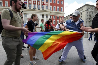 Un hombre intenta arrebatar una bandera de la comunidad homosexual a unos manifestantes en Moscú en el 2015.-REUTERS / MAXIM ZMEYEV