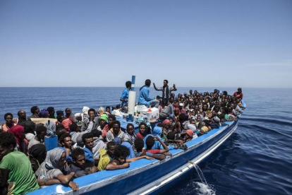 Inmigrantes a bordo de una patera intentando cruzar el Mediterráneo son rescatados por la Marina Militar italiana.-Foto: AFP / JASON FLORIO