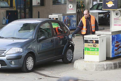 Un empleado de gasolinera echa combustible en un vehículo.-RAÚL G. OCHOA
