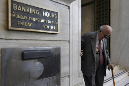 Un anciano griego sale de la sucursal de un banco.-Foto: AP / THANASSI STAVRAKIS
