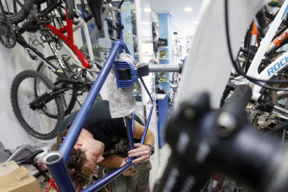 Un autónomo trabaja en su taller de bicicletas.-RAÚL G. OCHOA