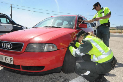 Dos agentes revisan la documentación y los neumáticos de un vehículo en la N-120 a la altura de San Medel.-ISRAEL L. MURILLO