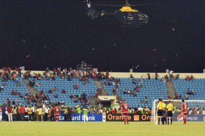 Un helicóptero de la Policía sobrevuela el estadio de Malabo entre una lluvia de objetos.-Foto: AFP / ISSOUF SANOGO