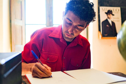 Sergi Torrecilla, ataviado con una camisa roja como la que vestía el maestro, firmó el libro de visitas de la Escuela de Bañuelos de Bureba. SERGI BERNAL