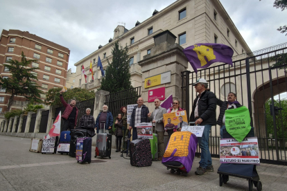 Los participantes en esta 'performance', con sus maletas frente a la Subdelegación del Gobierno.