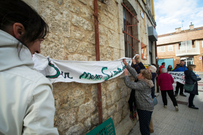 Los vecinos colocan una pancarta en el edificio del centro municipal donde se desarrollaron las elecciones el pasado 28 de mayo.