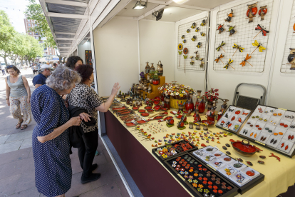 Una señora ojea los productos de un expositor en la Feria del Mimbre de Burgos