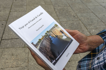 El autor sujeta un ejemplar de 'Viaje por el Canal de Castilla'.