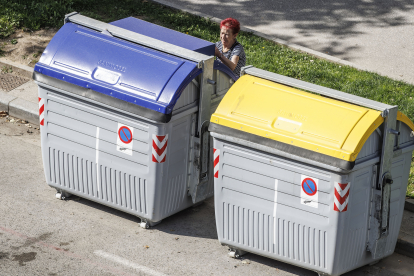 Una mujer deposita residuos en el contenedor de papel y cartón en la capital burgalesa.