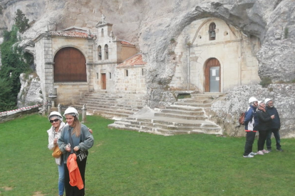 Turistas haciéndose fotos frente a San Bernabé tras culminar la visita a la cueva de Ojo Guareña.