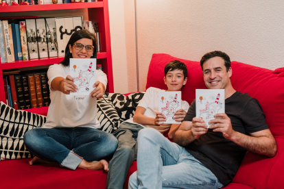 Cristina junto a Jorge, su marido, y Juan, su hijo, con el libro en la mano.