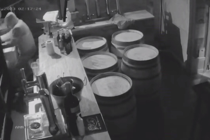 Fotograma de la grabación que muestra al ladrón tratando de arrancar el cajón de la recaudación.