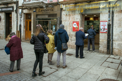 Varias personas hacen cola en una administración de Lotería de la capital burgalesa.