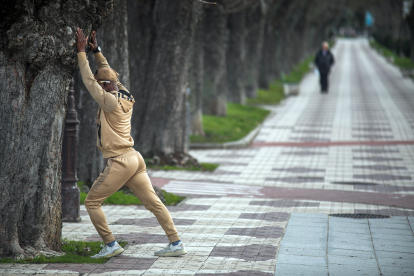 Un hombre realiza estiramientos aprovechando uno de los árboles del Espoloncillo.