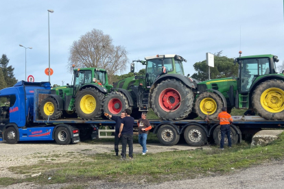 Tres tractores remolcados en una góndola antes de partir desde Burgos en dirección a Madrid.