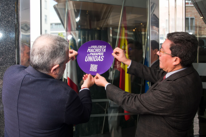 El subdelegado del Gobierno, Pedro de la Fuente, y el director provincial del SEPE, José Antonio Bouzón, colocan el distintivo del ‘punto violeta’.